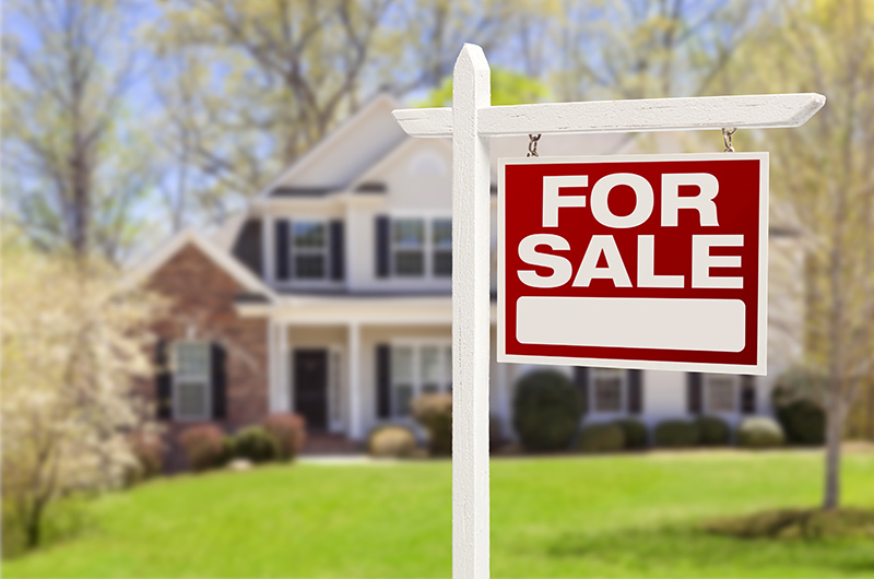 Home For Sale Real Estate Sign in Front of a New House.