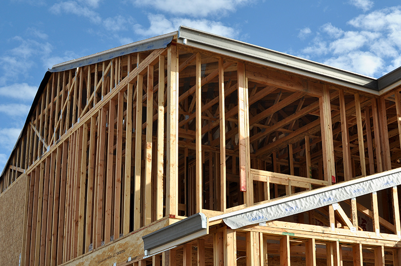 New home construction site showing wooden beam house structure.